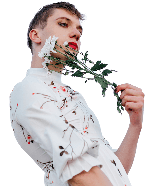 Person in a white floral blouse holding daisies against a clear sky